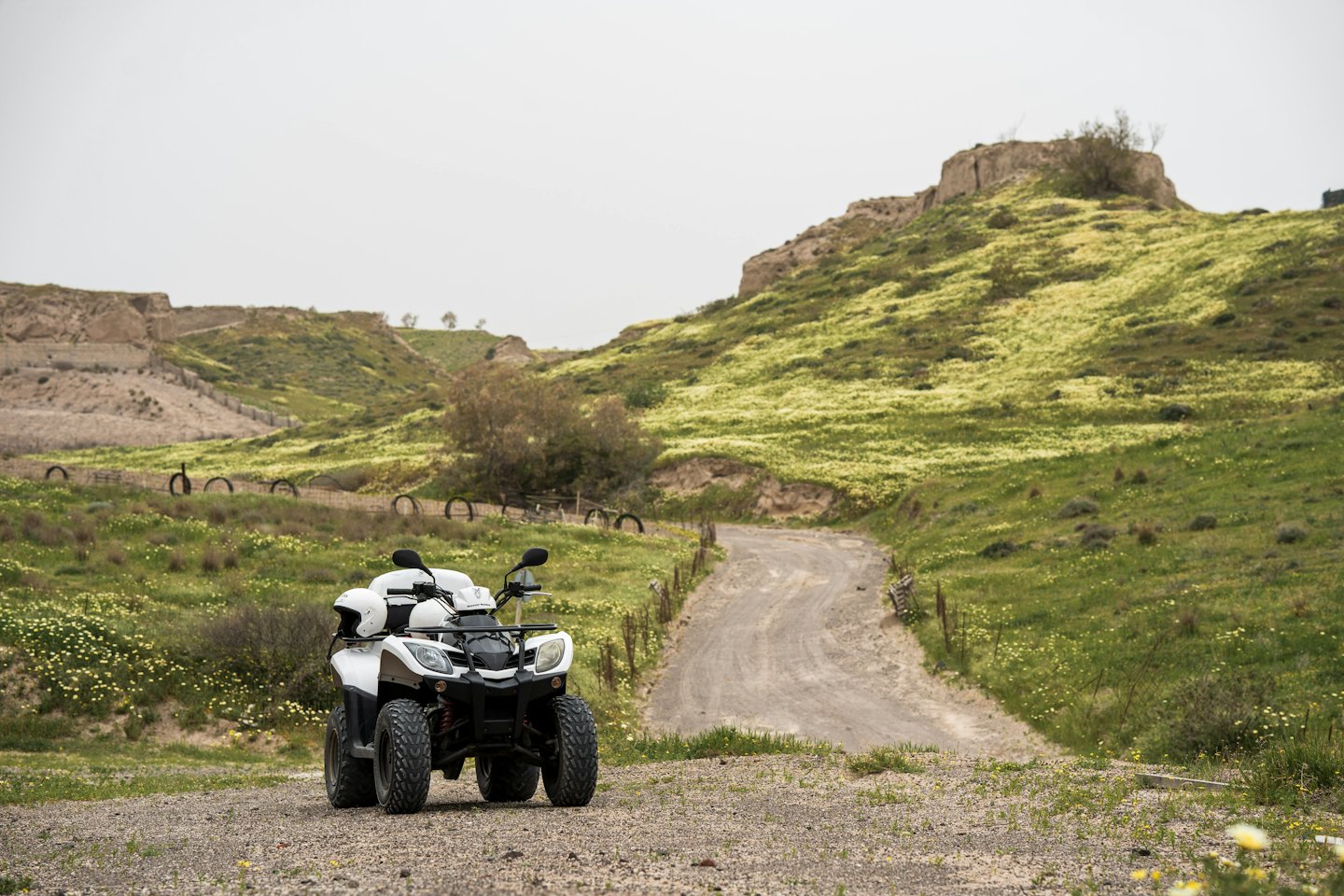 A white all-terrain vehicle parked on a winding gravel trail.